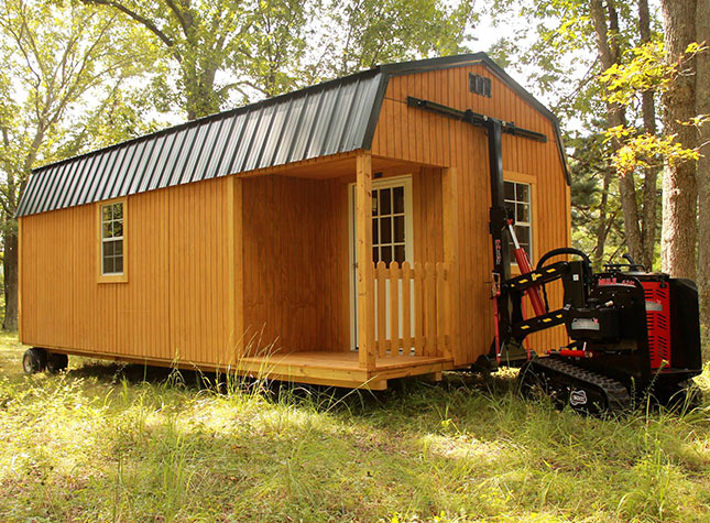 Cardinal Leasing portable cabin shed being moved with Cardinal Mule on a wooded property.